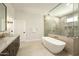 Modern bathroom with a soaking tub, glass shower, beautiful hardware, and a light color palette at 9900 N 52Nd St, Paradise Valley, AZ 85253