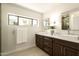 Bright bathroom with double sink vanity, stone countertops, and a window view to the outside at 9900 N 52Nd St, Paradise Valley, AZ 85253