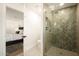Modern bathroom featuring a glass enclosed shower with unique herringbone tile and bedroom access at 9900 N 52Nd St, Paradise Valley, AZ 85253