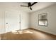 Minimalist bedroom with hardwood floors, ceiling fan, and a window offering natural light at 9900 N 52Nd St, Paradise Valley, AZ 85253