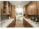 Butler's pantry with marble countertops, custom cabinets, and a view to the dining room at 9900 N 52Nd St, Paradise Valley, AZ 85253