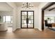 Elegant foyer with steel and glass doors, hardwood floors, and modern chandelier at 9900 N 52Nd St, Paradise Valley, AZ 85253