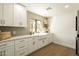 Bright kitchen features white cabinets, farmhouse sink, quartz countertop, and wood-look tile floors at 9900 N 52Nd St, Paradise Valley, AZ 85253