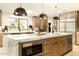 Close-up view of the kitchen island with marble waterfall countertop and stylish pendant lighting at 9900 N 52Nd St, Paradise Valley, AZ 85253