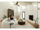 Living room with a round coffee table, a fireplace, hardwood floors, and a ceiling fan at 9900 N 52Nd St, Paradise Valley, AZ 85253