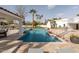 Beautiful pool area with a waterfall feature, cabana, lounge chairs, and lush landscaping for a serene outdoor retreat at 9900 N 52Nd St, Paradise Valley, AZ 85253