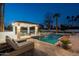Inviting backyard pool area with covered cabana and lounge chairs illuminated at dusk at 9900 N 52Nd St, Paradise Valley, AZ 85253
