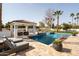Relaxing pool area with a cabana, spa, lounge chairs, and travertine decking perfect for soaking up the sun at 9900 N 52Nd St, Paradise Valley, AZ 85253