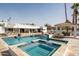 Beautiful pool featuring a tiled spa, waterfall feature, and a covered cabana with outdoor kitchen at 9900 N 52Nd St, Paradise Valley, AZ 85253