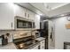 Compact kitchen with modern appliances, white cabinetry, and functional design with updated appliances at 1021 S Greenfield Rd # 1178, Mesa, AZ 85206
