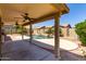 Outdoor patio with ceiling fans overlooking a private pool and lush backyard landscaping at 11318 S Hopi Dr, Goodyear, AZ 85338