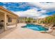 A beautiful backyard featuring an in-ground pool with rock waterfall feature and mature tropical landscaping at 11318 S Hopi Dr, Goodyear, AZ 85338