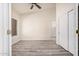 This carpetless bedroom features a modern ceiling fan, a vaulted ceiling, and a closet with sliding doors at 11318 S Hopi Dr, Goodyear, AZ 85338