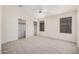 This is a bright bedroom with two closets, neutral carpeting, and two windows with blinds at 11318 S Hopi Dr, Goodyear, AZ 85338