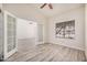 Carpetless bedroom featuring high ceilings, modern ceiling fan, a large window, and glass paned french doors at 11318 S Hopi Dr, Goodyear, AZ 85338