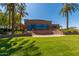 Exterior of the clubhouse with a patio area, grassy lawn, and palm trees at 11318 S Hopi Dr, Goodyear, AZ 85338