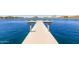 Picturesque lake view featuring a private dock with seating areas under a bright, sunny sky at 11318 S Hopi Dr, Goodyear, AZ 85338