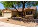 Charming single-story home with a three car garage and mature shade tree in the front yard at 11318 S Hopi Dr, Goodyear, AZ 85338