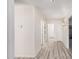 Hallway featuring modern flooring, neutral paint, and multiple doors for easy access to the rest of the home at 11318 S Hopi Dr, Goodyear, AZ 85338