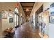 Well-lit hallway featuring tiled floors, arched doorways, and displays of local art at 11318 S Hopi Dr, Goodyear, AZ 85338