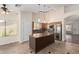 Well-lit kitchen featuring an island, stainless steel appliances, and tiled floors at 11318 S Hopi Dr, Goodyear, AZ 85338