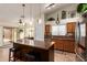Spacious kitchen showcasing an island with stool seating, a tile floor, and modern lighting at 11318 S Hopi Dr, Goodyear, AZ 85338