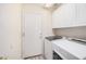 This laundry room has overhead cabinets, modern machines, and access to the backyard through a side door at 11318 S Hopi Dr, Goodyear, AZ 85338