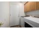 Laundry room features wood cabinets and white washer and dryer units at 11318 S Hopi Dr, Goodyear, AZ 85338