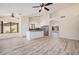 Bright living room open to the kitchen features modern floors, neutral paint, and lots of natural light at 11318 S Hopi Dr, Goodyear, AZ 85338