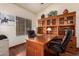 Warm and inviting office with a large desk, leather chairs and built-in shelving at 11318 S Hopi Dr, Goodyear, AZ 85338