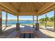 Lake view from a covered picnic area featuring picnic tables and many palm trees at 11318 S Hopi Dr, Goodyear, AZ 85338