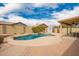 Sparkling pool in a private backyard with lush landscaping and a covered patio at 11318 S Hopi Dr, Goodyear, AZ 85338