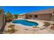 Backyard featuring a uniquely shaped private pool surrounded by desert landscaping and rock features at 11318 S Hopi Dr, Goodyear, AZ 85338