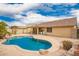 Beautiful backyard pool featuring a covered patio and desert landscaping at 11318 S Hopi Dr, Goodyear, AZ 85338