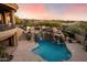 Aerial view of a luxury backyard featuring a pool with waterfall, outdoor kitchen and dining area at 11988 E Larkspur Dr, Scottsdale, AZ 85259