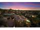 Night aerial view of a large estate, featuring a pool, tile roof, and desert landscaping in a scenic setting at 11988 E Larkspur Dr, Scottsdale, AZ 85259