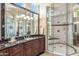 This main bathroom features a glass enclosed shower, dark cabinets, dual sinks, and an elegant marble countertop at 11988 E Larkspur Dr, Scottsdale, AZ 85259
