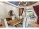 Dining room with wood table, upholstered chairs, statement ceiling, hardwood floors, and natural light at 11988 E Larkspur Dr, Scottsdale, AZ 85259