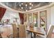 Dining room features a wooden table, upholstered chairs, an artistic ceiling, and natural light at 11988 E Larkspur Dr, Scottsdale, AZ 85259