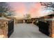 Gated entrance leading to a luxurious estate with a spacious driveway and beautiful desert landscaping at 11988 E Larkspur Dr, Scottsdale, AZ 85259
