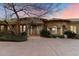 Elegant exterior elevation with stone accents, columns, and lush landscaping creating a welcoming entrance at 11988 E Larkspur Dr, Scottsdale, AZ 85259