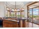 Gourmet kitchen offering wood cabinets, granite countertops, an island sink, and outdoor access at 11988 E Larkspur Dr, Scottsdale, AZ 85259