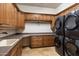 Spacious laundry room with ample cabinet storage, counter space, sink, and stacked washer/dryer at 11988 E Larkspur Dr, Scottsdale, AZ 85259