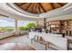 Spacious living room with built-ins, fireplace, beamed ceiling, and access to outdoor seating with mountain view at 11988 E Larkspur Dr, Scottsdale, AZ 85259