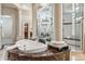 A spa-like main bathroom showcases a soaking tub, decorative glass, pillars and a glass enclosed shower at 11988 E Larkspur Dr, Scottsdale, AZ 85259