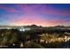 Night view showcases city lights with mountain silhouettes against a vibrant purple and pink sky at 11988 E Larkspur Dr, Scottsdale, AZ 85259