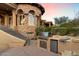 Outdoor kitchen with stainless steel grill, bar, and sink built into stone structure, convenient for backyard entertaining at 11988 E Larkspur Dr, Scottsdale, AZ 85259