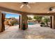 Expansive covered patio with travertine flooring overlooking the pool area, seamlessly blending indoor and outdoor living spaces at 11988 E Larkspur Dr, Scottsdale, AZ 85259