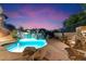 Stunning backyard pool with rock waterfall feature, built-in spa, and professional landscaping at 11988 E Larkspur Dr, Scottsdale, AZ 85259