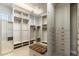 Well-organized walk-in closet with custom shelving, drawers, mirrors, and bench seating at 11988 E Larkspur Dr, Scottsdale, AZ 85259